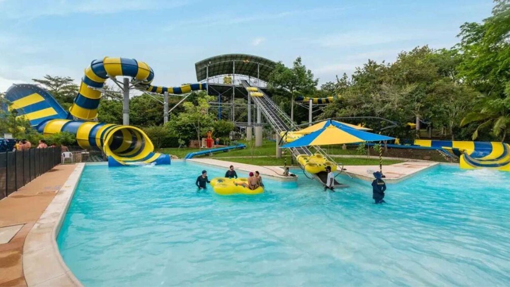 A water park with a large pool, yellow and blue water slides, and inflatable rafts. 5