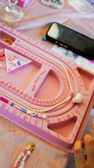 A pink bead design board with numbered sections and beads arranged in patterns. 5