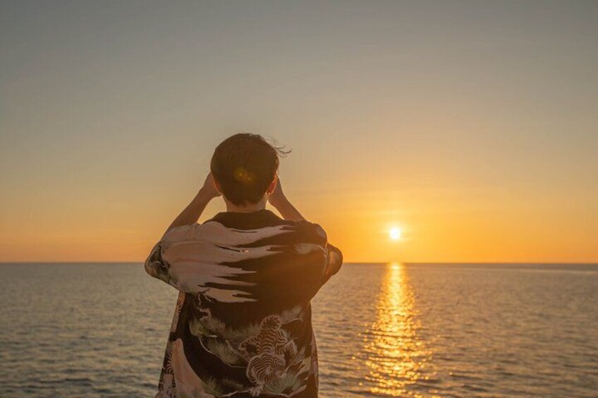 A person standing by the sea during sunset. 3