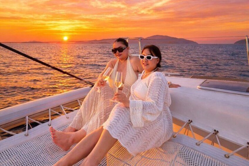 Two people on a boat at sunset with the sun visible. 1