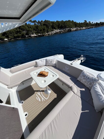 A boat's deck with a table, cushions, and a loaf of bread. 3