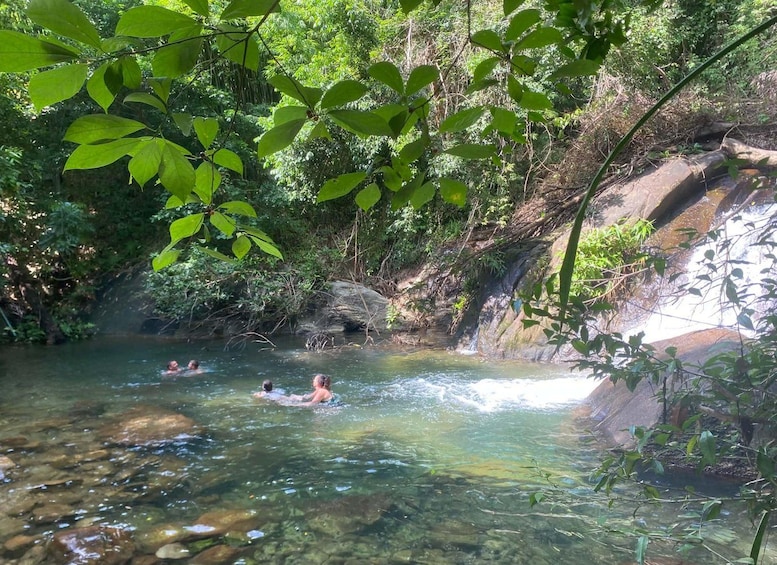 A natural water body surrounded by greenery and rocks. 2
