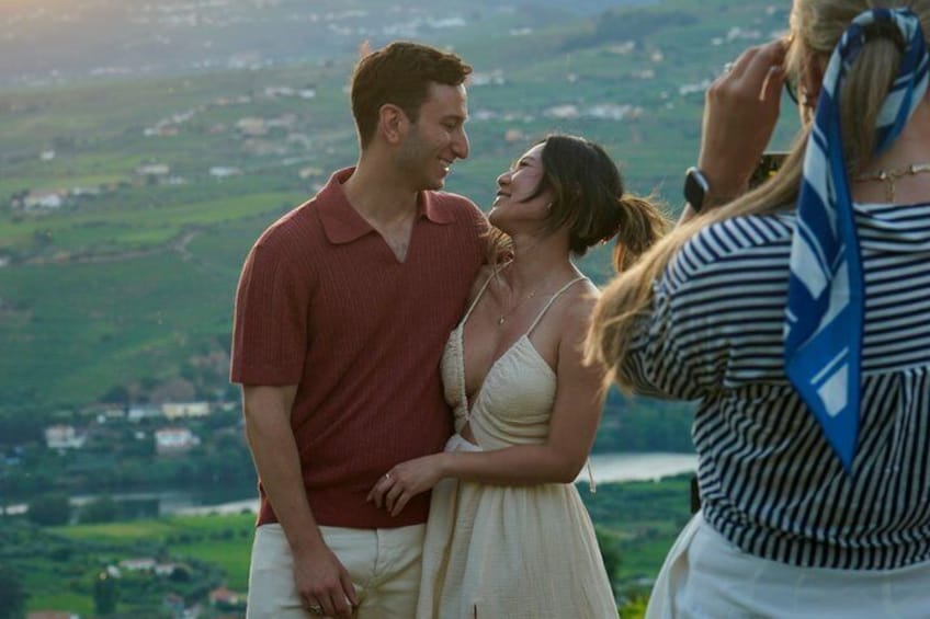A couple embracing with a scenic landscape in the background. 1