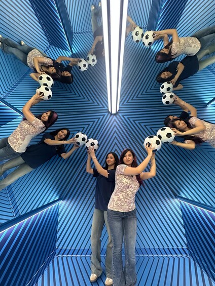 A group of people holding soccer balls in a blue-striped tunnel. 5