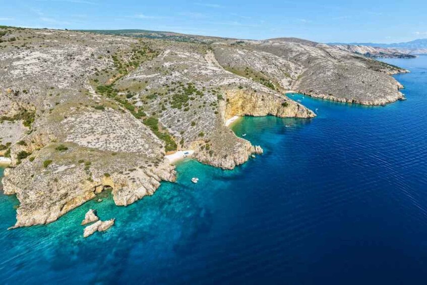 A rugged coastline with clear blue waters and rocky terrain. 3