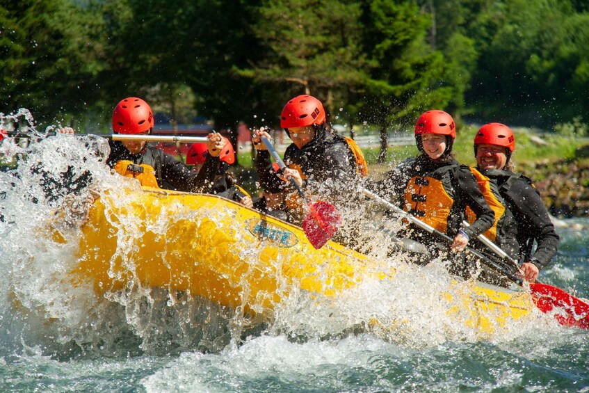 A group of people in a yellow raft navigating through a river with splashes of water. 3
