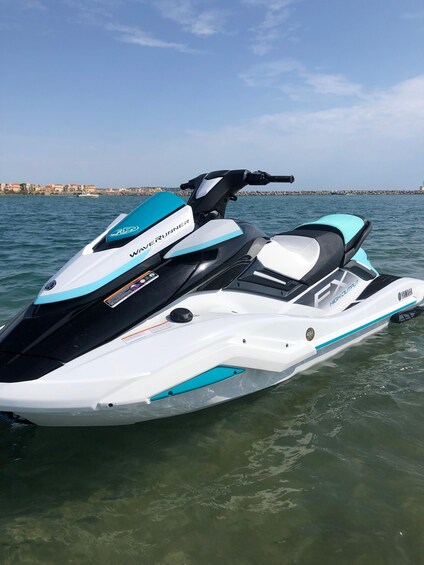 A Yamaha WaveRunner jet ski in clear water with a coastal cityscape in the background. 3