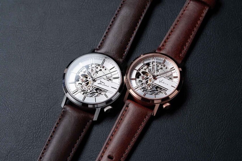 Two watches with exposed gears on a dark surface. 5