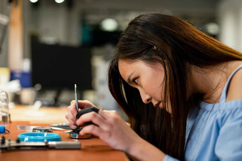 A person using a smartphone at a table with various objects. 1