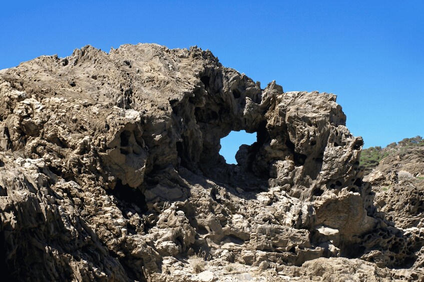 A rocky landscape with a prominent arch formation. 2