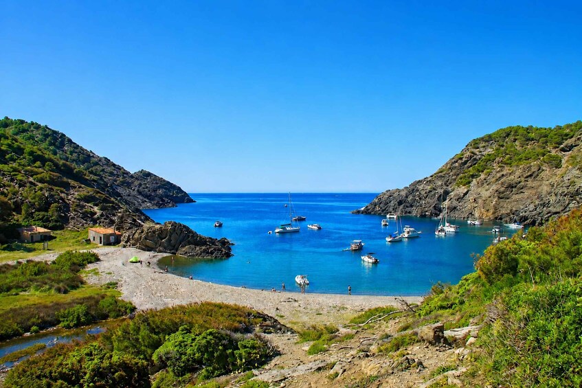 A coastal bay with boats, rocky shores, and greenery. 4