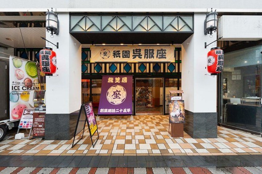 A storefront with a tiled floor, a signboard, and a poster. 5