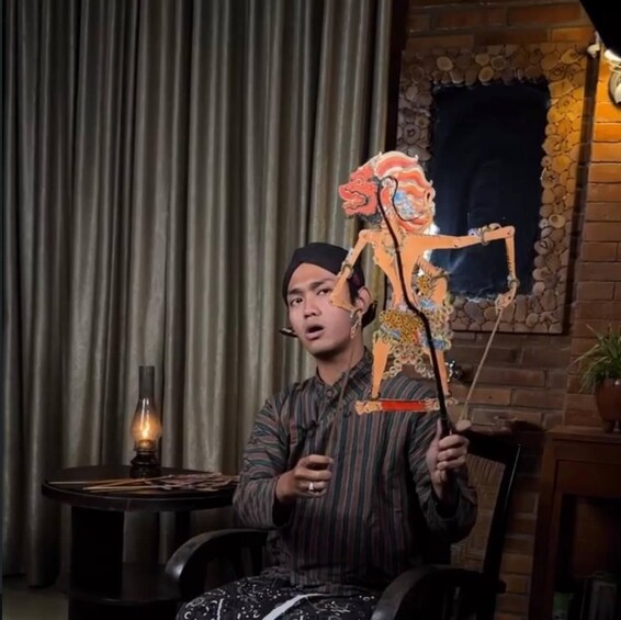 A person holding a colorful paper cutout of a figure. 3