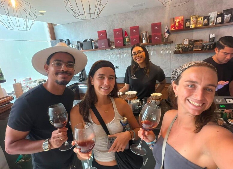 A group of people holding wine glasses at a bar with shelves of bottles and boxes in the background. 4
