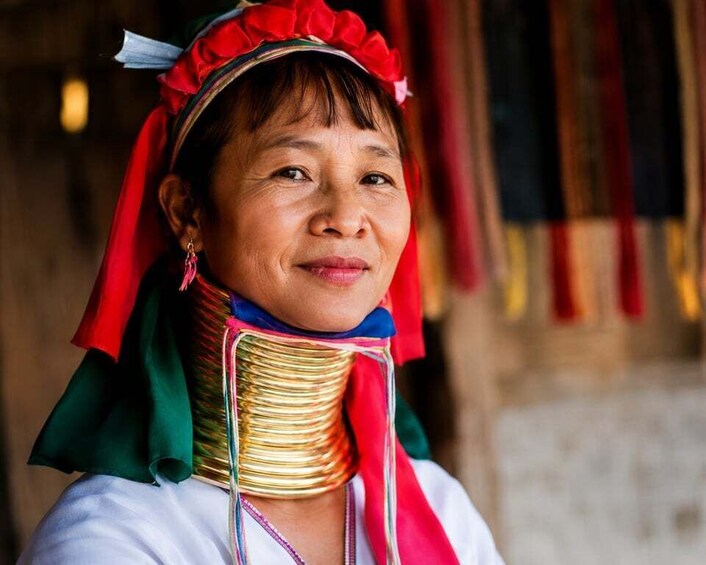 A person wearing traditional attire with a red headpiece and a white garment. 1