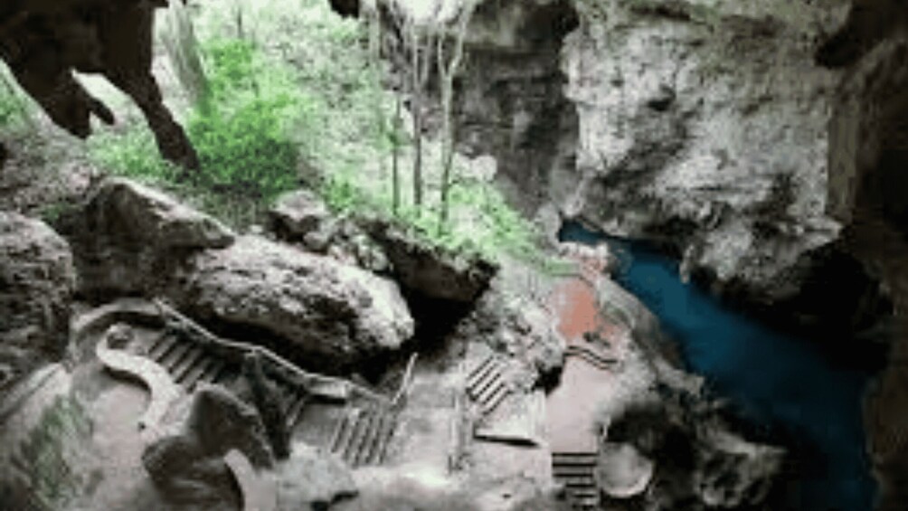 A cave with a water stream, rocky formations, and a spiral staircase. 3