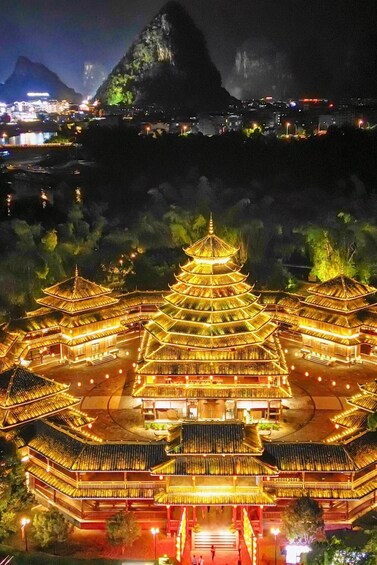 A traditional multi-tiered pagoda illuminated at night with a mountainous backdrop. 3