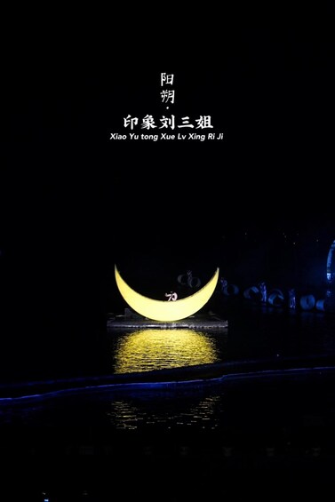 A crescent moon illuminated above a body of water with a reflection. 1
