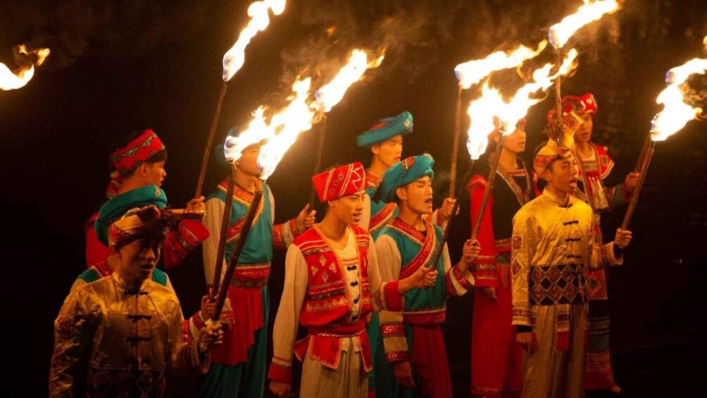 A group of people in traditional costumes holding torches. 5