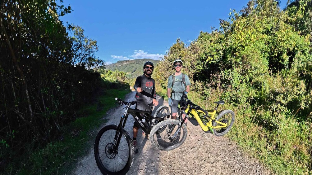 Two cyclists on a gravel path surrounded by greenery. 2