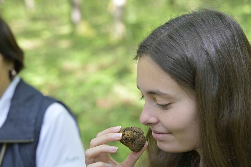 A person holding a rock outdoors. 4