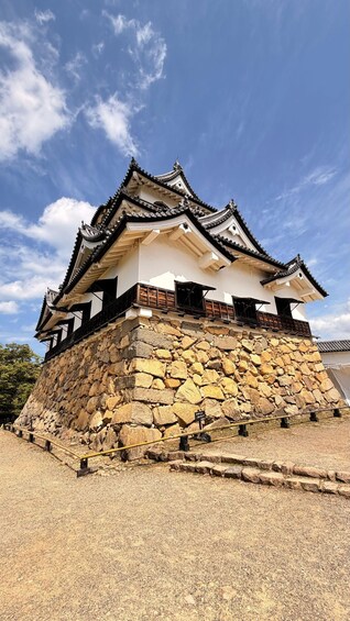 A traditional Japanese castle with a stone base and ornate black and white architecture. 4