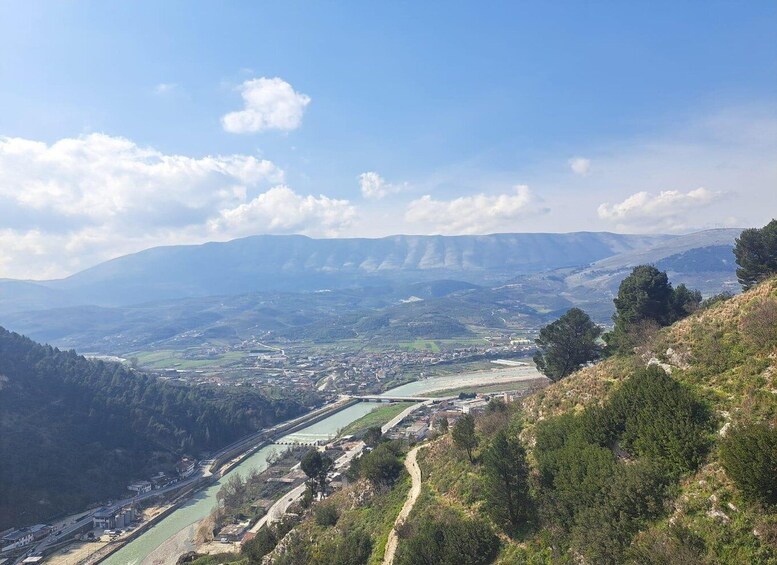 A valley with a river, a town, and distant mountains. 4