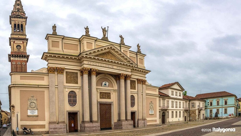 A historic church with a bell tower and statues, surrounded by traditional buildings. 3