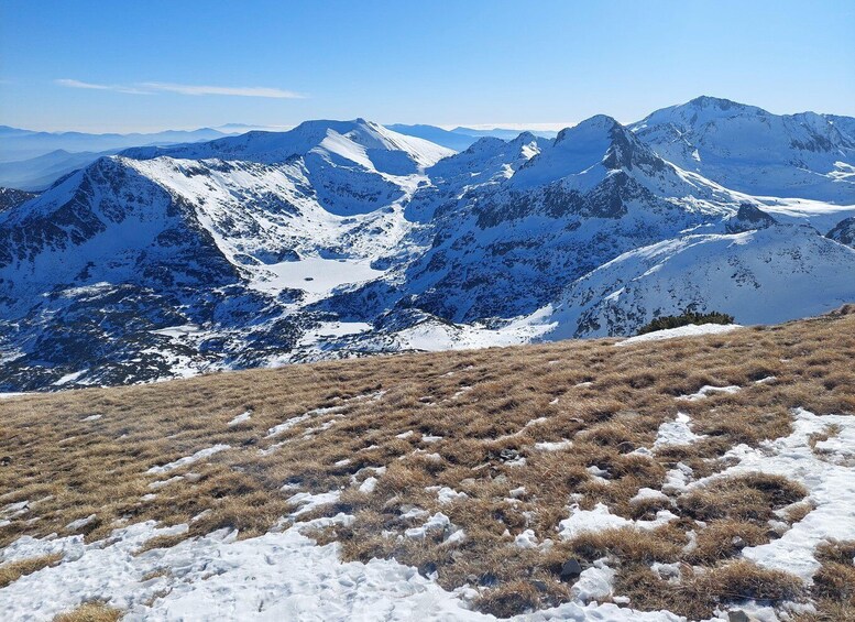 A snow-covered mountain range with a clear sky. 2