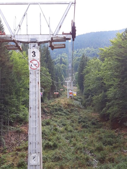 A mountain ski lift with a sign indicating a height limit of 3 meters. 3