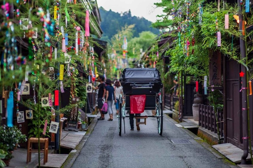 A narrow street lined with traditional buildings, decorated with colorful paper strips and ornaments. 5
