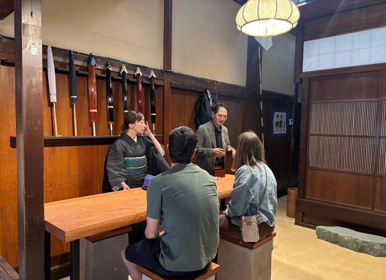A traditional Japanese restaurant with wooden interiors and a group of people seated at a table. 1