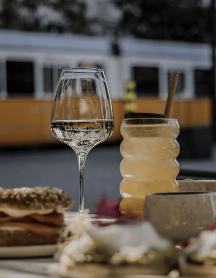 A glass of clear liquid, a honey jar, and a wooden spoon on a table. 3