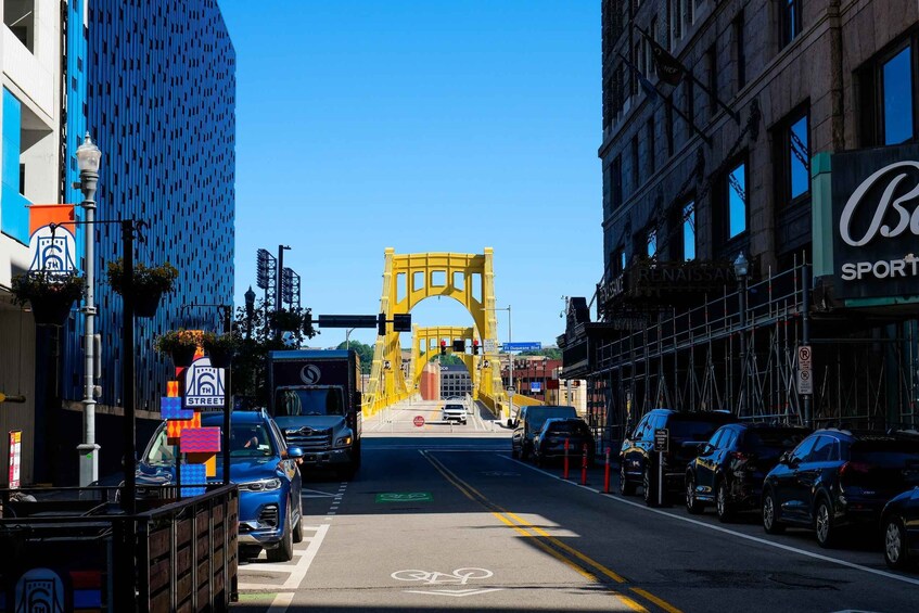 A city street with a yellow bridge, parked cars, and a bicycle lane. 4