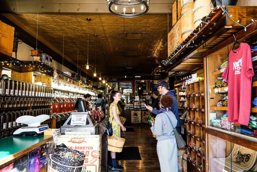 A coffee shop interior with wooden shelves, a cash register, and a customer interacting with a staff member. 3