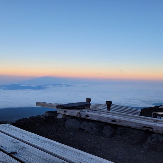 A wooden viewing platform overlooking a sea of clouds at sunrise. 4