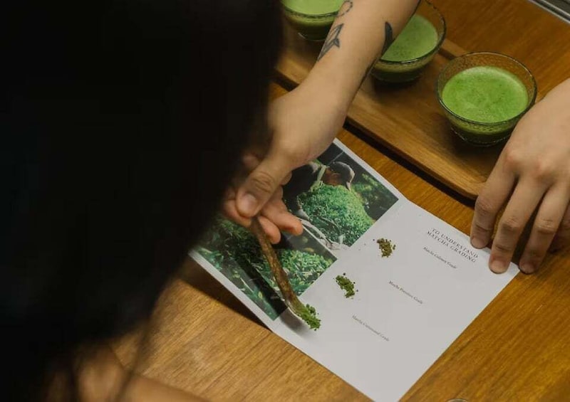 A person reading a matcha tea guide. 1