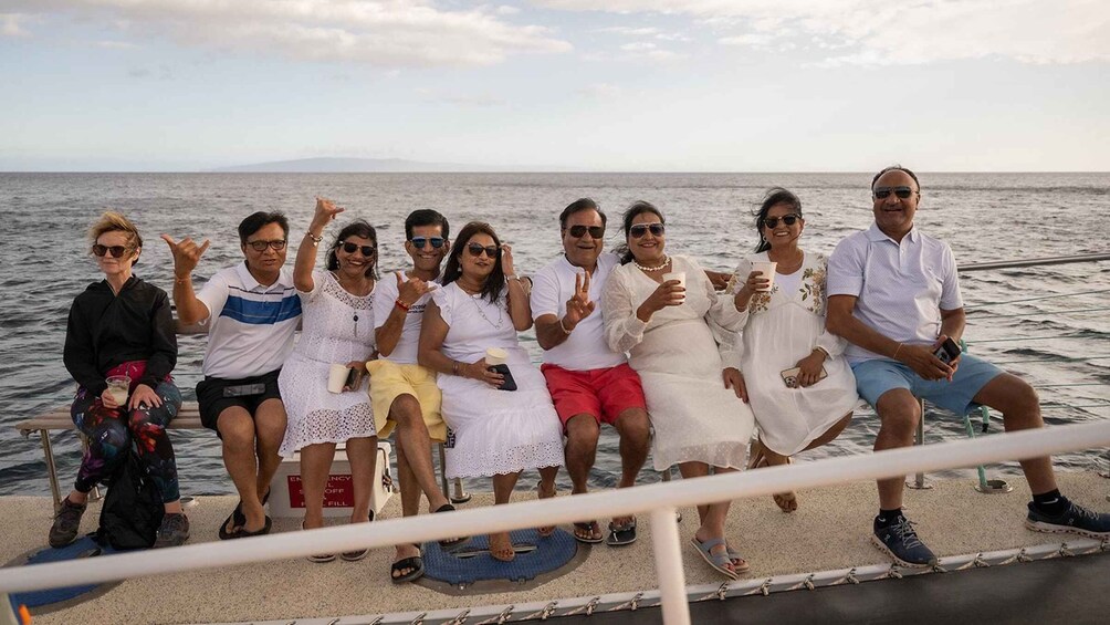 A group of people on a boat with the sea and a distant shoreline in the background. 2