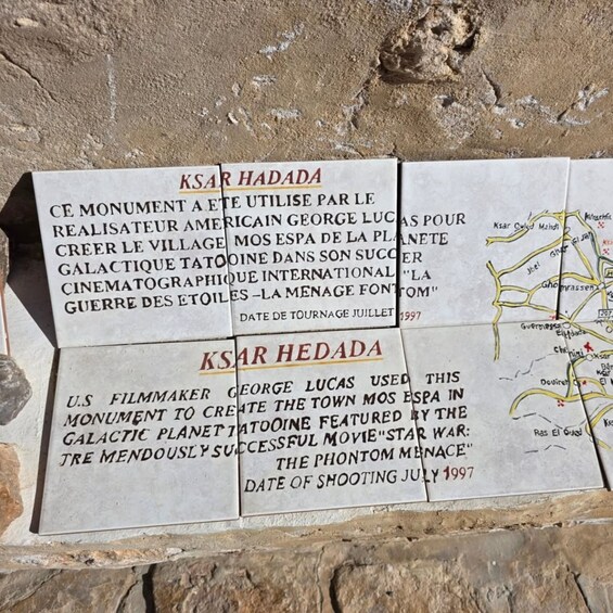 A monument with inscriptions in French and English, mentioning George Lucas and a movie. 4