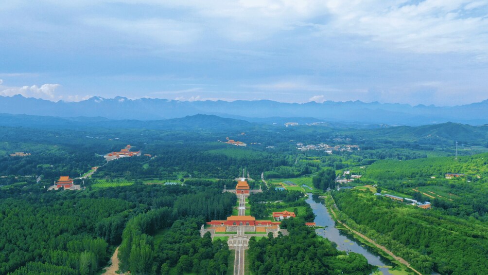 A mountainous landscape with a temple complex and a river. 1