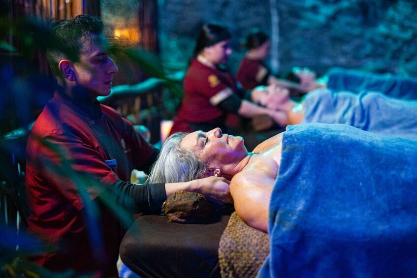A person receiving a massage in a dimly lit room with a rustic ambiance. 2