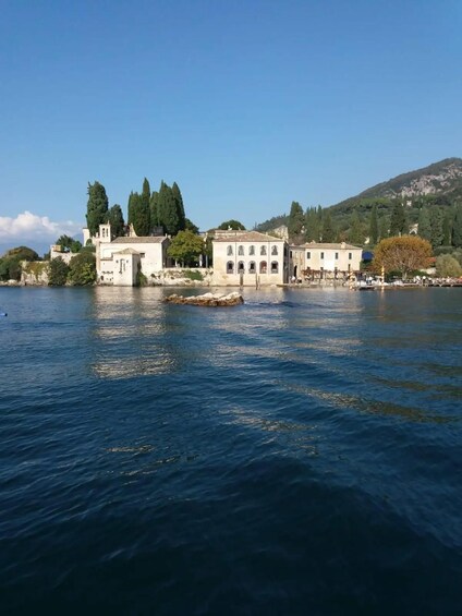 A coastal town with historic buildings by the sea, a clear sky, and a mountain in the background. 5