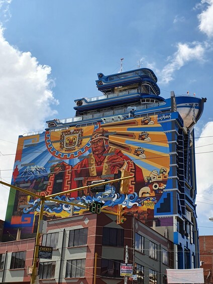 A building with a colorful mural featuring a figure in a crown and a mountain landscape. 4