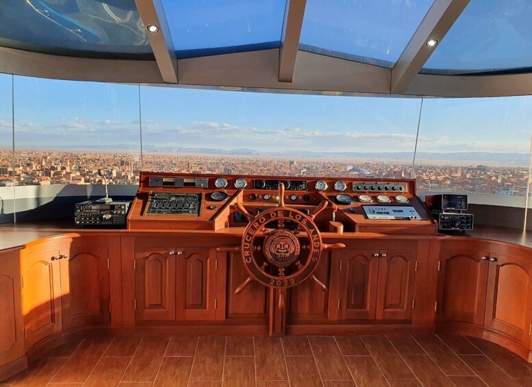 A ship's control room with a steering wheel, multiple dials, and a panoramic city view. 1