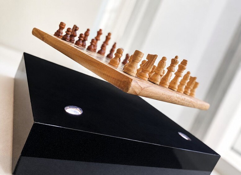 A wooden chessboard on a black stand. 4