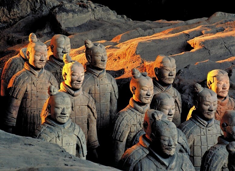 Terracotta soldiers in a row, standing in a rocky terrain. 3