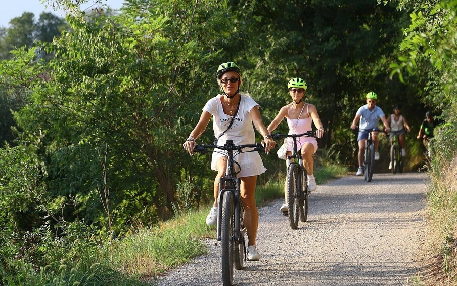 Cyclists on a gravel path surrounded by greenery. 3