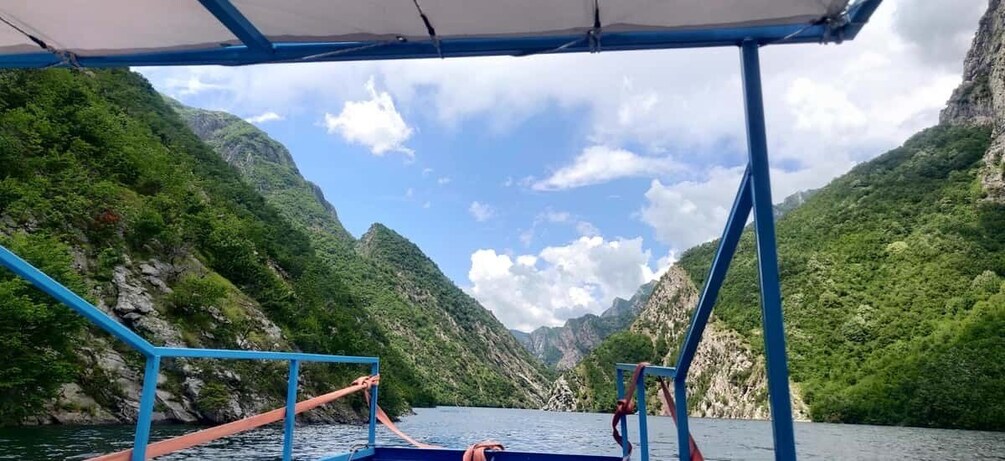 A boat on a river with mountainous terrain on both sides. 5