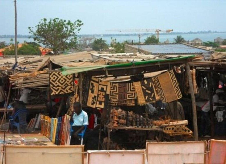 A market with patterned fabrics and wooden items on display. 2