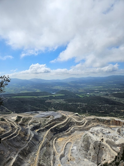 A mountainous landscape with mining operations and distant hills. 3